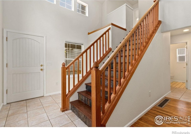 1382 Warbler St, Loveland, CO 80537 - stairway with baseboards, tile patterned floors, and a high ceiling