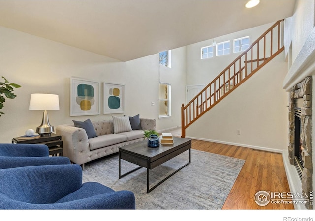 1382 Warbler St, Loveland, CO 80537 - living room featuring stairway, wood finished floors, baseboards, and a fireplace