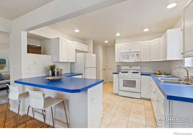1382 Warbler St, Loveland, CO 80537 - kitchen with white appliances, a sink, dark countertops, white cabinetry, and recessed lighting