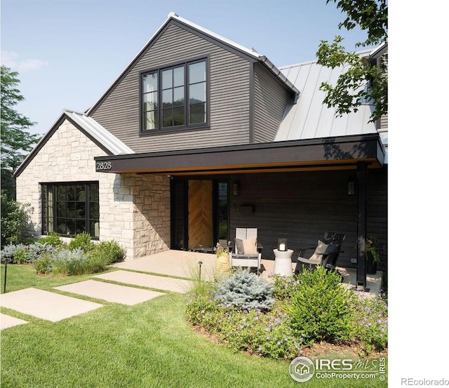 2828 4th St, Boulder, CO 80304 - view of front facade featuring stone siding, a front yard, covered porch, a standing seam roof, and metal roof