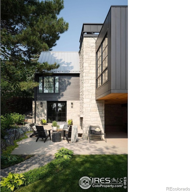 2828 4th St, Boulder, CO 80304 - rear view of property with a patio area, a standing seam roof, stone siding, board and batten siding, and metal roof