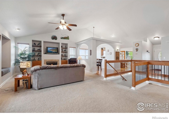 6911 W 22nd St, Greeley, CO 80634 - living room featuring a ceiling fan, carpet, a tiled fireplace, lofted ceiling, and baseboards