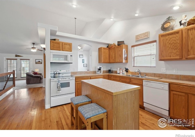 6911 W 22nd St, Greeley, CO 80634 - kitchen with white appliances, a sink, lofted ceiling, arched walkways, and light countertops