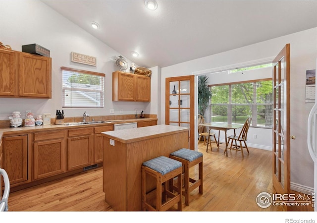 6911 W 22nd St, Greeley, CO 80634 - kitchen with a sink, lofted ceiling, light countertops, light wood finished floors, and a kitchen island