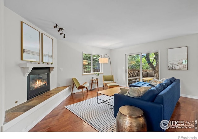 1409 Quince Ave, Boulder, CO 80304 - living area featuring wood finished floors, a glass covered fireplace, baseboards, and rail lighting