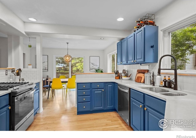 1409 Quince Ave, Boulder, CO 80304 - kitchen with stainless steel appliances, a sink, blue cabinetry, light wood-type flooring, and backsplash