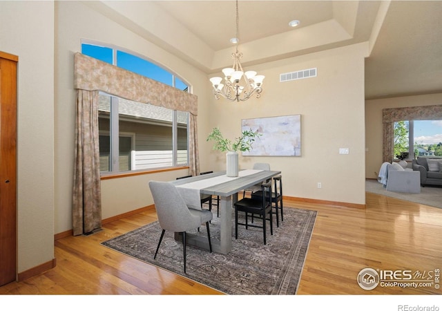 6787 Spanish Bay Dr, Windsor, CO 80550 - dining room with wood finished floors, a tray ceiling, a chandelier, and baseboards