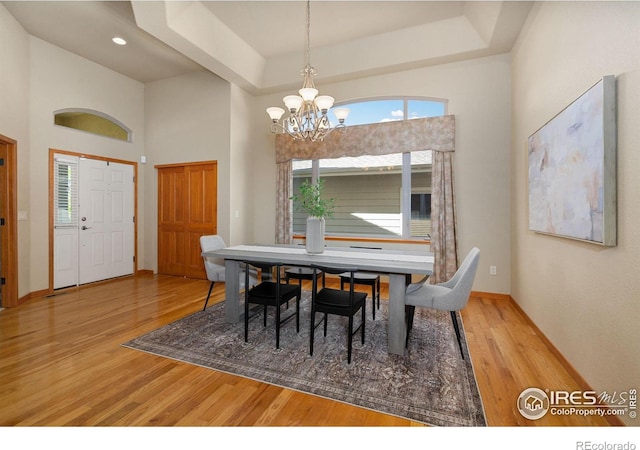 6787 Spanish Bay Dr, Windsor, CO 80550 - dining area with a chandelier, wood finished floors, baseboards, and a high ceiling