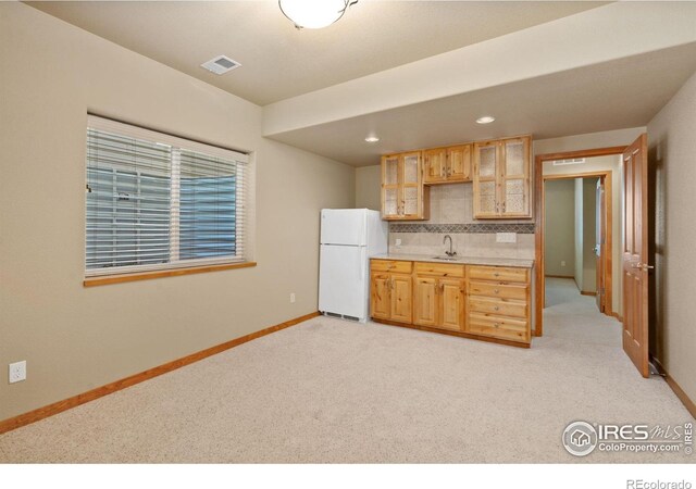 6787 Spanish Bay Dr, Windsor, CO 80550 - kitchen with freestanding refrigerator, a sink, light colored carpet, glass insert cabinets, and recessed lighting