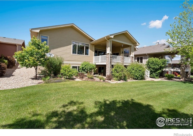 6787 Spanish Bay Dr, Windsor, CO 80550 - rear view of house with a yard and a balcony