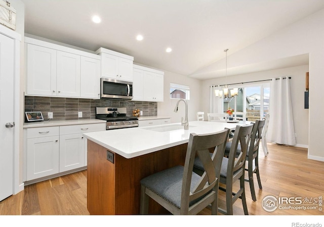 7025 Meadow Rain Way, Wellington, CO 80549 - kitchen featuring stainless steel appliances, a sink, a chandelier, lofted ceiling, and tasteful backsplash