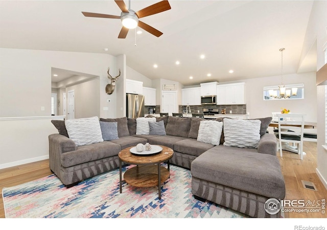 7025 Meadow Rain Way, Wellington, CO 80549 - living room with light wood-style floors, vaulted ceiling, a chandelier, a ceiling fan, and recessed lighting