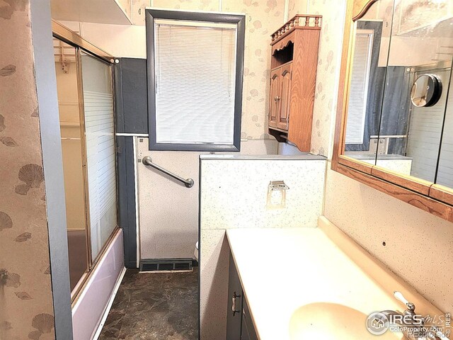 402 N Washington Ave, Fleming, CO 80728 - full bathroom featuring vanity, shower / bath combination with glass door, and toilet