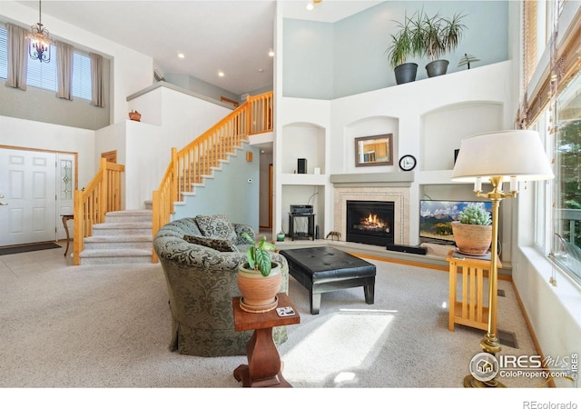 140 Camino Real Ft, Collins, CO 80524 - carpeted living room featuring a towering ceiling, stairway, and a warm lit fireplace