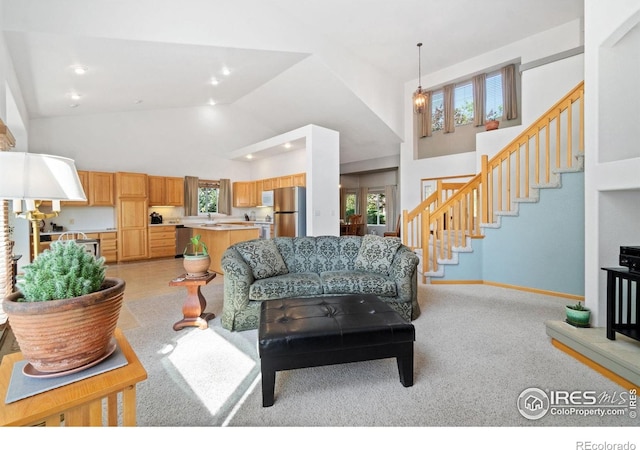 140 Camino Real Ft, Collins, CO 80524 - living area with high vaulted ceiling, plenty of natural light, stairway, light carpet, and baseboards