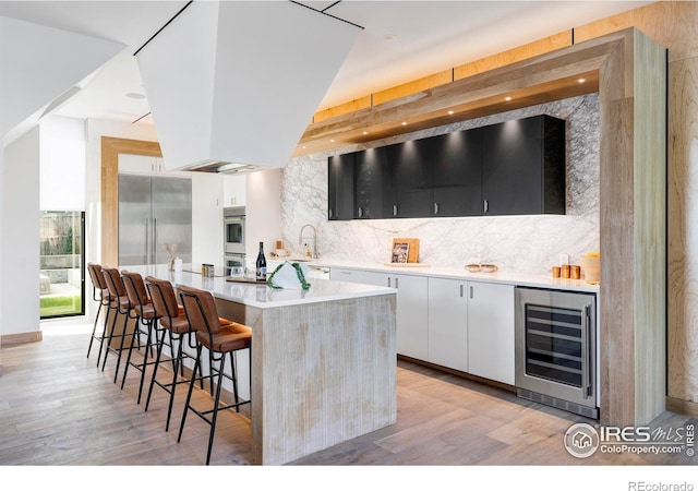 944 Arapahoe Ave Unit A, Boulder, CO 80302 - indoor bar with wine cooler, decorative backsplash, light wood finished floors, and appliances with stainless steel finishes