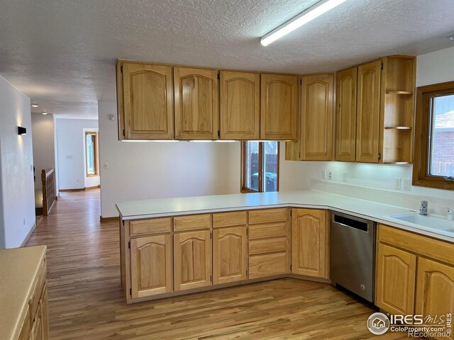 1126 Patricia Dr, Loveland, CO 80537 - kitchen featuring dishwasher, a sink, light wood finished floors, a textured ceiling, and light countertops