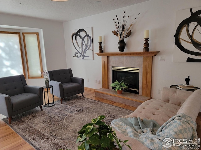 1126 Patricia Dr, Loveland, CO 80537 - living area featuring wood finished floors, a tile fireplace, and a textured ceiling