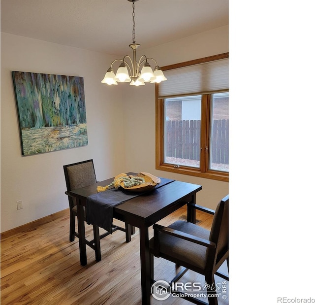 1126 Patricia Dr, Loveland, CO 80537 - dining room featuring a chandelier, light wood-style floors, and baseboards
