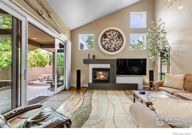 3345 15th St, Boulder, CO 80304 - living area with wood finished floors, a glass covered fireplace, baseboards, and high vaulted ceiling
