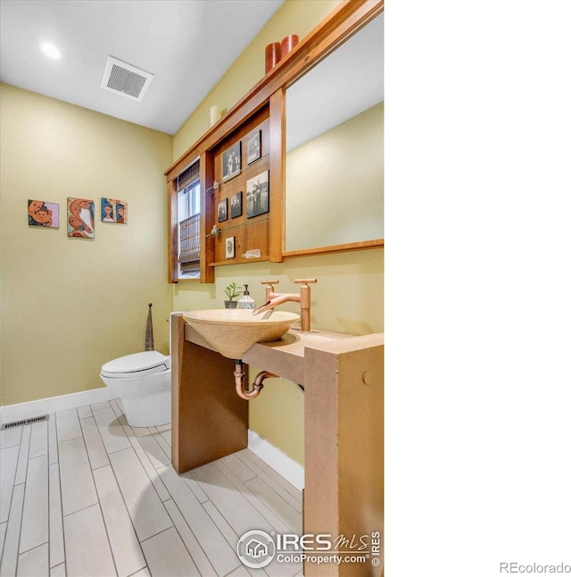 3345 15th St, Boulder, CO 80304 - bathroom featuring toilet, baseboards, a sink, and recessed lighting