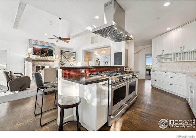 3401 E County Road 16, Loveland, CO 80537 - kitchen featuring double oven range, island range hood, a ceiling fan, a brick fireplace, and recessed lighting