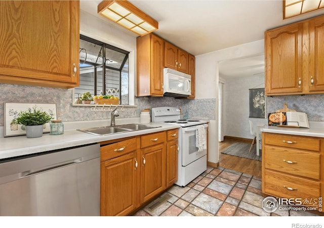 911 Timber Ct, Longmont, CO 80504 - kitchen featuring white appliances, a sink, light countertops, and tasteful backsplash