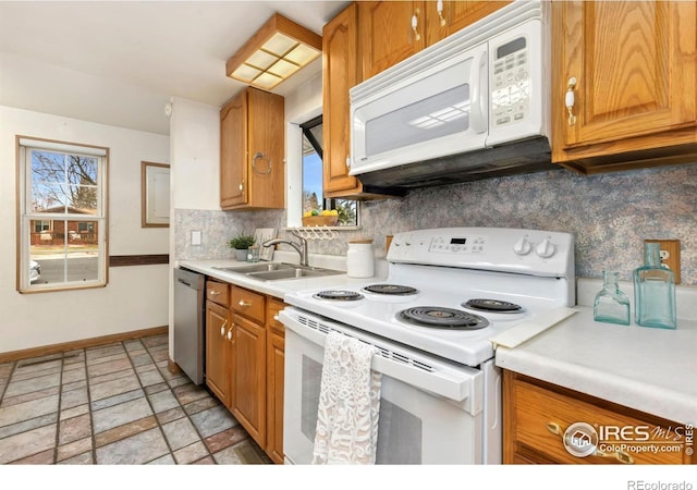 911 Timber Ct, Longmont, CO 80504 - kitchen with white appliances, baseboards, healthy amount of natural light, and light stone finish floors