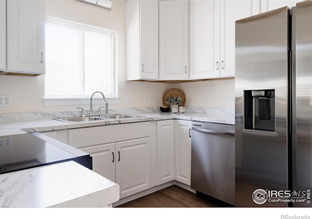 934 6th St, Berthoud, CO 80513 - kitchen with appliances with stainless steel finishes, a sink, white cabinetry, and dark wood-style floors