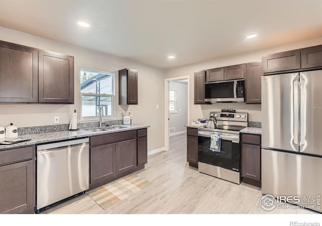 3014 High Dr, Evans, CO 80620 - kitchen featuring stainless steel appliances, a sink, light wood-type flooring, baseboards, and dark brown cabinets