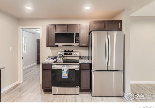 3014 High Dr, Evans, CO 80620 - kitchen featuring appliances with stainless steel finishes, light wood-type flooring, dark brown cabinets, baseboards, and light stone countertops