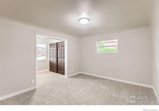 3014 High Dr, Evans, CO 80620 - spare room featuring carpet, a textured ceiling, and baseboards