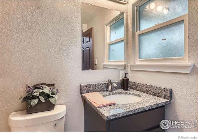 3014 High Dr, Evans, CO 80620 - bathroom with toilet, vanity, and a textured wall