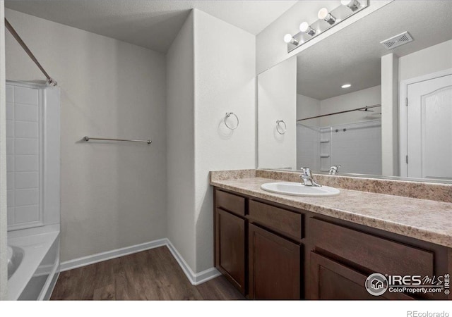 1426 Sepia Ave, Longmont, CO 80501 - bathroom with wood finished floors, vanity, washtub / shower combination, and baseboards