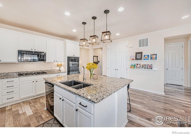 6253 Black Mesa Rd, Frederick, CO 80516 - kitchen with black appliances, a sink, light wood-style flooring, white cabinets, and recessed lighting