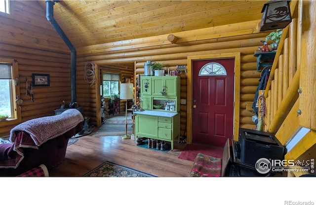 311 Chiricahua Cir, Red Feather Lakes, CO 80545 - foyer entrance with healthy amount of natural light, a wood stove, wood finished floors, log walls, and high vaulted ceiling