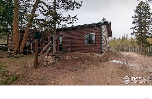311 Chiricahua Cir, Red Feather Lakes, CO 80545 - rear view of house featuring faux log siding and an outbuilding