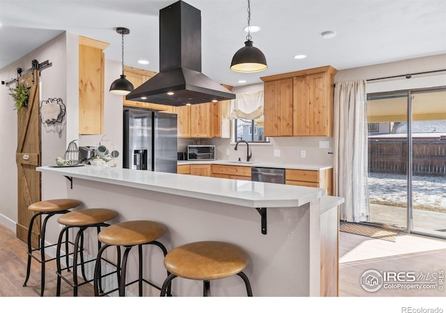 2408 Albany Ave, Loveland, CO 80538 - kitchen with island exhaust hood, stainless steel appliances, a sink, light brown cabinetry, and light wood finished floors