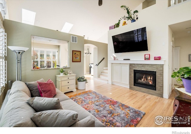 2758 Meadow Mountain Trl, Lafayette, CO 80026 - living room featuring a towering ceiling, a skylight, a fireplace, wood finished floors, and stairs