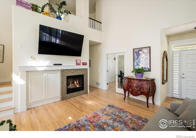 2758 Meadow Mountain Trl, Lafayette, CO 80026 - living area with light wood-style flooring, a glass covered fireplace, and baseboards