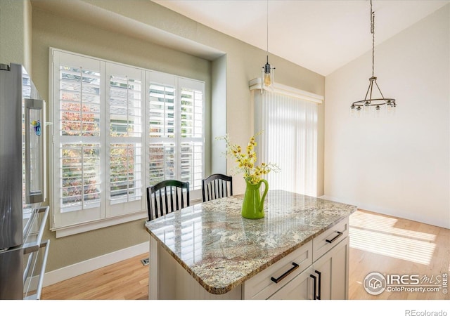 2758 Meadow Mountain Trl, Lafayette, CO 80026 - kitchen featuring light stone counters, light wood-style floors, baseboards, hanging light fixtures, and white cabinets