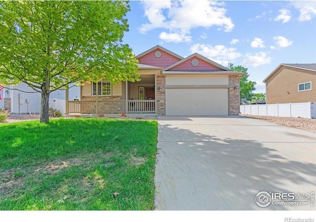 8734 19th Street Rd, Greeley, CO 80634 - view of front of house with a porch, a garage, driveway, and stone siding