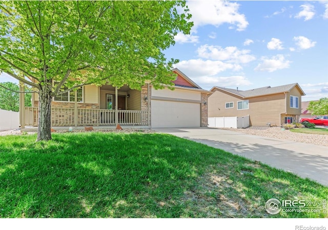 8734 19th Street Rd, Greeley, CO 80634 - view of front of house featuring an attached garage, driveway, a porch, and stone siding