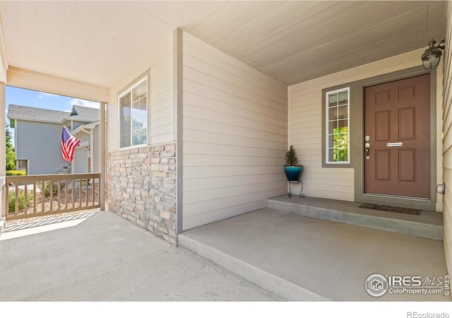 8734 19th Street Rd, Greeley, CO 80634 - doorway to property featuring a porch and stone siding