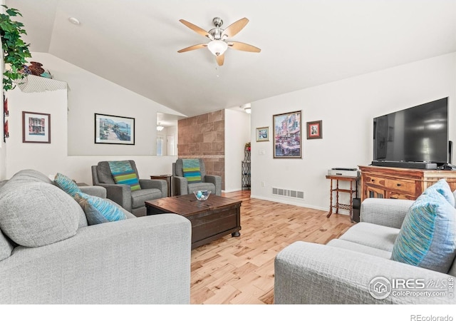 8734 19th Street Rd, Greeley, CO 80634 - living area with vaulted ceiling, a ceiling fan, light wood finished floors, a fireplace, and baseboards