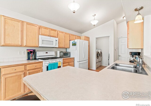 8734 19th Street Rd, Greeley, CO 80634 - kitchen featuring white appliances, a sink, light brown cabinets, washing machine and clothes dryer, and lofted ceiling