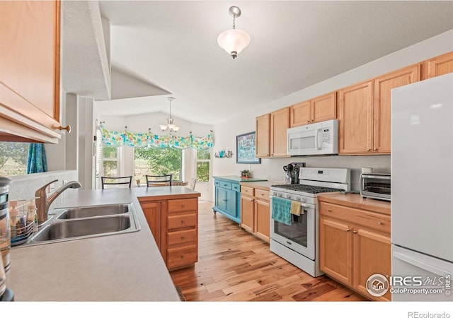 8734 19th Street Rd, Greeley, CO 80634 - kitchen featuring white appliances, a sink, lofted ceiling, a chandelier, and light wood-type flooring