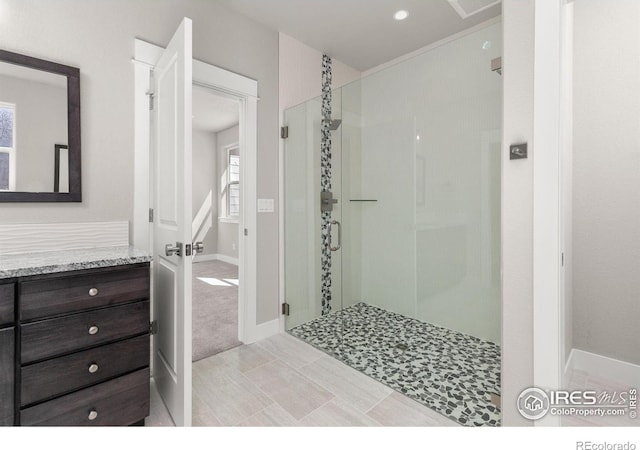 1128 N 5th St, Johnstown, CO 80534 - bathroom featuring a stall shower, plenty of natural light, vanity, and baseboards