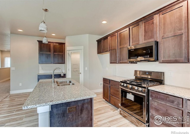 1128 N 5th St, Johnstown, CO 80534 - kitchen with stainless steel appliances, a sink, baseboards, wood tiled floors, and recessed lighting