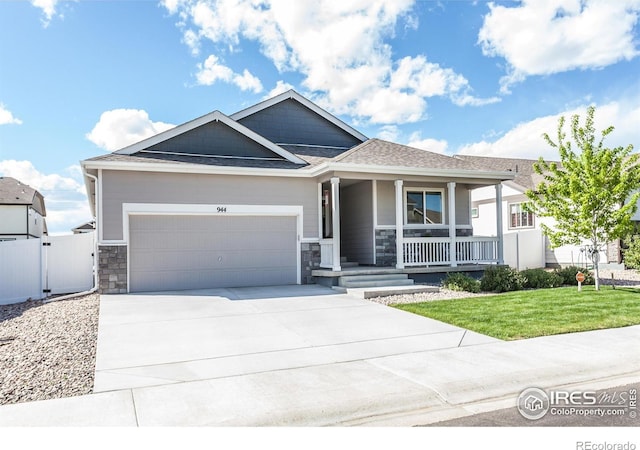 944 Maplebrook Dr, Windsor, CO 80550 - single story home featuring covered porch, an attached garage, concrete driveway, stone siding, and roof with shingles